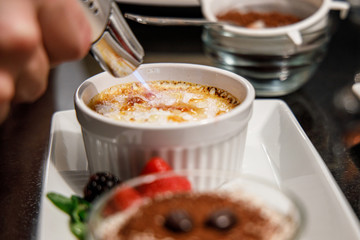 Creme Brulee Zucker karamellisieren mit einem Brenner in der Küche