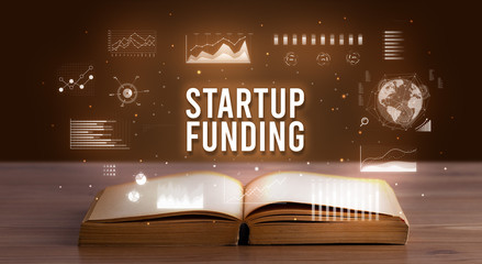 STARTUP FUNDING inscription coming out from an open book, creative business concept