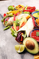 Mexican food, including tacos, guacamole, nachos and pepper on rustic table