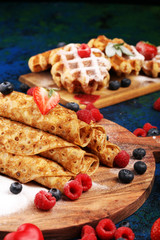 Delicious Tasty Homemade crepes or pancakes with raspberries and mint on rustic background