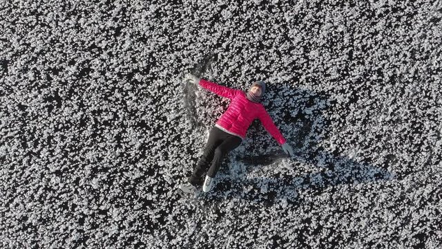 Girl ice skating roll on a frozen huge pond. View from above. Snc with a quadcopter