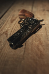 Historic revolver pistol on old wooden floor.