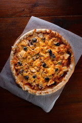 Pizza on a wooden dark background in a bar