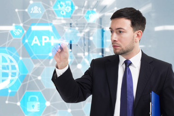 Obraz premium Business, Technology, Internet and network concept. Young businessman working on a virtual screen of the future and sees the inscription: API