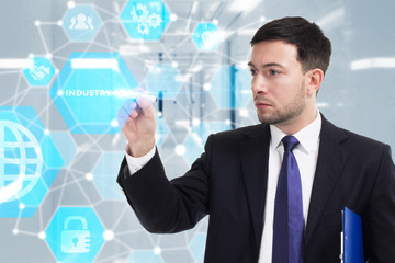 Obraz premium Business, Technology, Internet and network concept. Young businessman working on a virtual screen of the future and sees the inscription: Industry 4.0