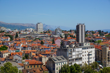 Fototapeta premium View of the eastern part of Split from the bell tower of the Split Palace. Picturesque mountains, tiled roofs of old houses, modern hotels, a school, a hospital