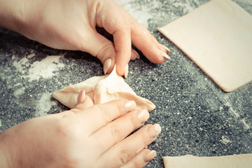 hands of the girl sculpts pies from the dough
