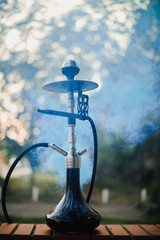 Hookah outdoors on a background of colored smoke