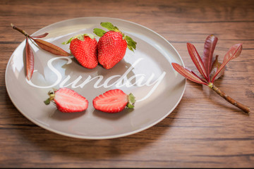 Ripe red strawberries disk on wooden table.