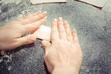 hands of the girl sculpts pies from the dough