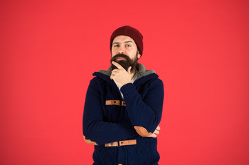 Obraz premium Posing for photo. thinking bearded man in knitted jacket. you need to dress warmly. male winter fashion. take care of beard hair in cold weather. autumn and winter collection. brutal hipster in hat