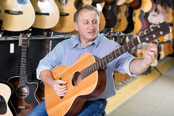Man is playing on acoustic guitar