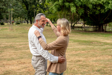 Fototapeta premium Portrait Caucasian elder couple are dancing in park. Happy elder couple concept