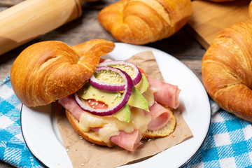 Fototapeta na wymiar Butter croissant bread with ham and cheese on wooden background