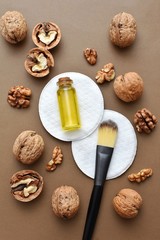 Obraz na płótnie Canvas Walnut oil and brush on cosmetic pads, natural skin and hair care, beauty self care product, flat lay.