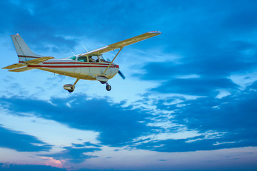 Fototapeta na wymiar Small plane airborne against sky