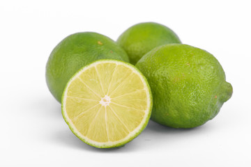 Fresh lime, half and quarter part on white background. Green citrus fruit. 