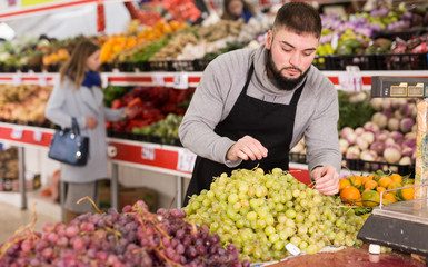 Market worker puts vegetables on the counter