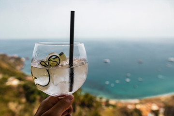 Cucumber cocktail drink in front of tropical sea