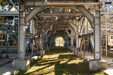 Industrial equipment. Pipeline overpass - bottom view. Metal structures at the factory.