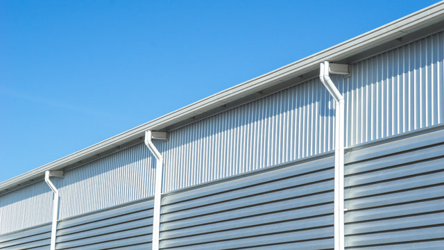 Close up wall and roof of Factory or warehouse building in industrial estate with blue sky and copyspace