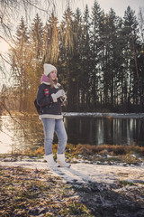 Fototapeta premium Generation z traveler girl walks through a forest park with hot coffee in a thermos zero waste, shoots a video for a blog, freelance work