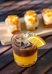 Coffee with orange juice and orange bread on a wooden table