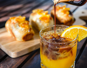 Coffee with orange juice and orange bread on a wooden table