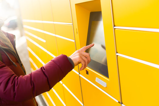 Munich, Germany - Dec 5th, 2019: A woman uses the automated postal service DHL.
