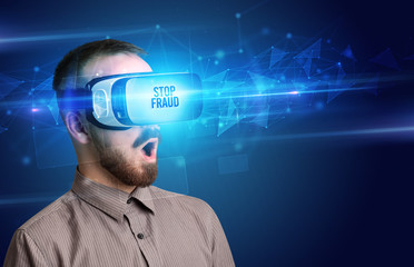 Businessman looking through Virtual Reality glasses with STOP FRAUD inscription, cyber security concept