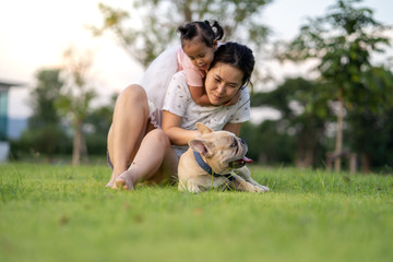 Happy little girl playing with her mum in park at noon.