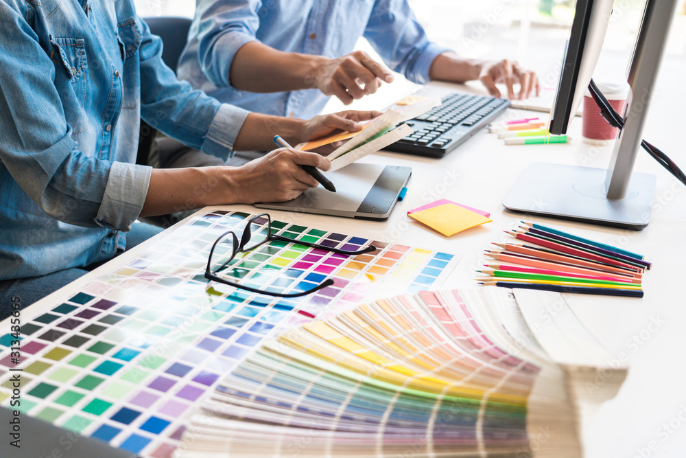 Poster designer graphic creative creativity working together coloring using graphics tablet and a stylus at