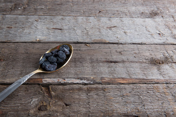 raisins photo of in metal spoon on brown wooden table