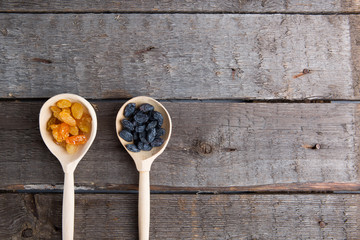Raisins in a wooden spoon. Rustic style.