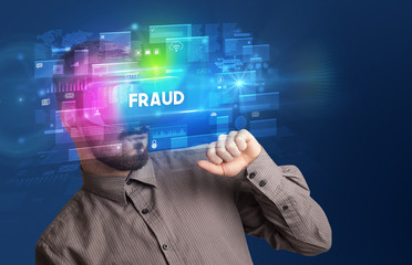 Businessman looking through Virtual Reality glasses with FRAUD inscription, innovative security concept