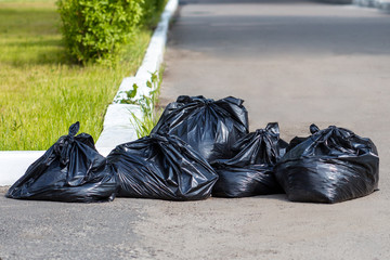 Black bags with garbage on the streets of the city
