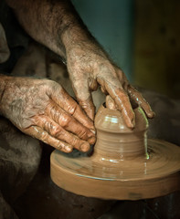 Potters hands moulding wet clay pots 