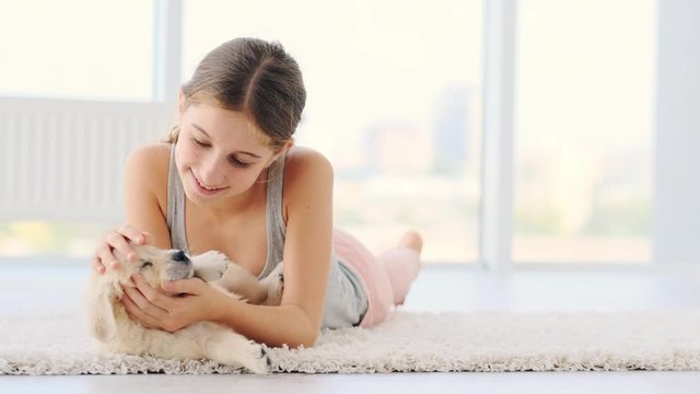 Female child lying on floor with cute young dog