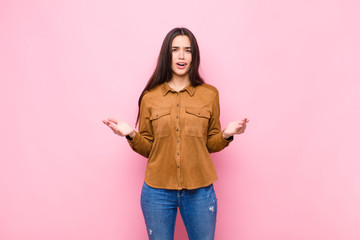 young pretty woman open-mouthed and amazed, shocked and astonished with an unbelievable surprise...