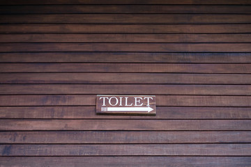 Toilet Sign on Plank Wall