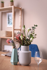 Vase with beautiful flowers on wooden table indoors. Element of modern interior