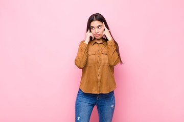 young pretty woman looking concentrated and thinking hard on an idea, imagining a solution to a...