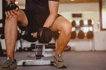 fitness, jogging, running, exercise, lifestyle and healthy concept. Young men wear sportswear, prepare dumbbell weights for exercise in the gym at sunset.