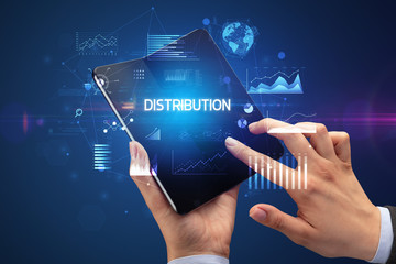 Businessman holding a foldable smartphone with DISTRIBUTION inscription, successful business concept