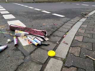 Ausgebranntes Feuerwerk der Silvesternacht zeigt an Neujahr die Feuergefahr und den M&uuml;ll der Feuerwerksk&ouml;rper und Raketen zum Jahreswechsel als Verletzungsgefahr, Brandgefahr und Umweltverschmutzung