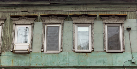 Fototapeta na wymiar antique wooden windows carved platbands in the village, Russian outback