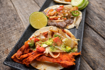 Mexican tacos on wooden background