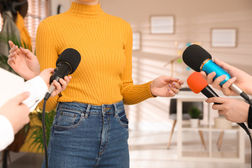 Group of journalists interviewing woman in room, closeup