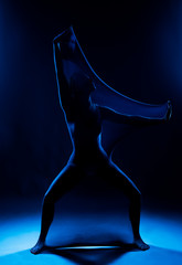 Slim girl wearing a white bodysuit dances a modern avant garde dance, covering her body with...