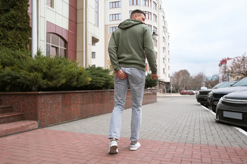 Man suffering from hemorrhoid pain outdoors, back view
